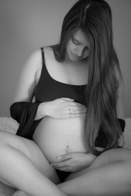 a pregnant woman is sitting on a bed