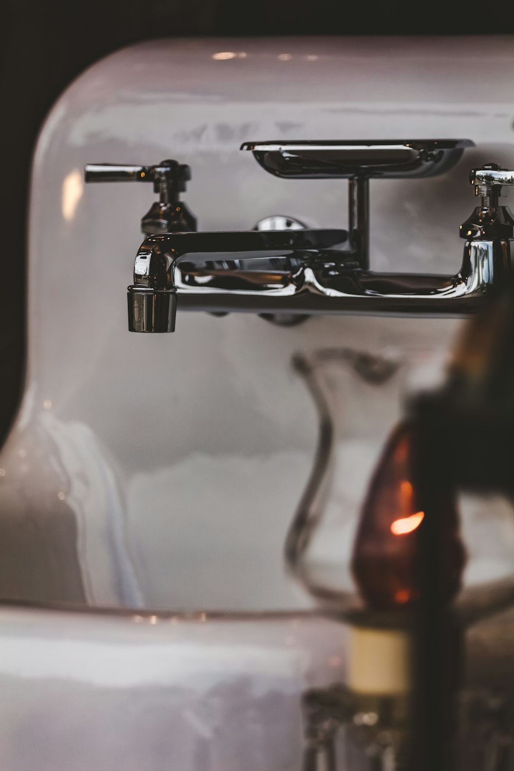 a close up of a sink with a faucet and soap dispense