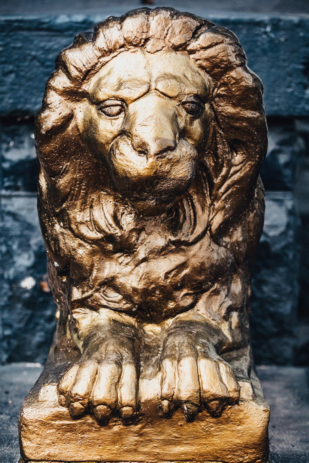 a statue of a lion sitting on top of a wooden block