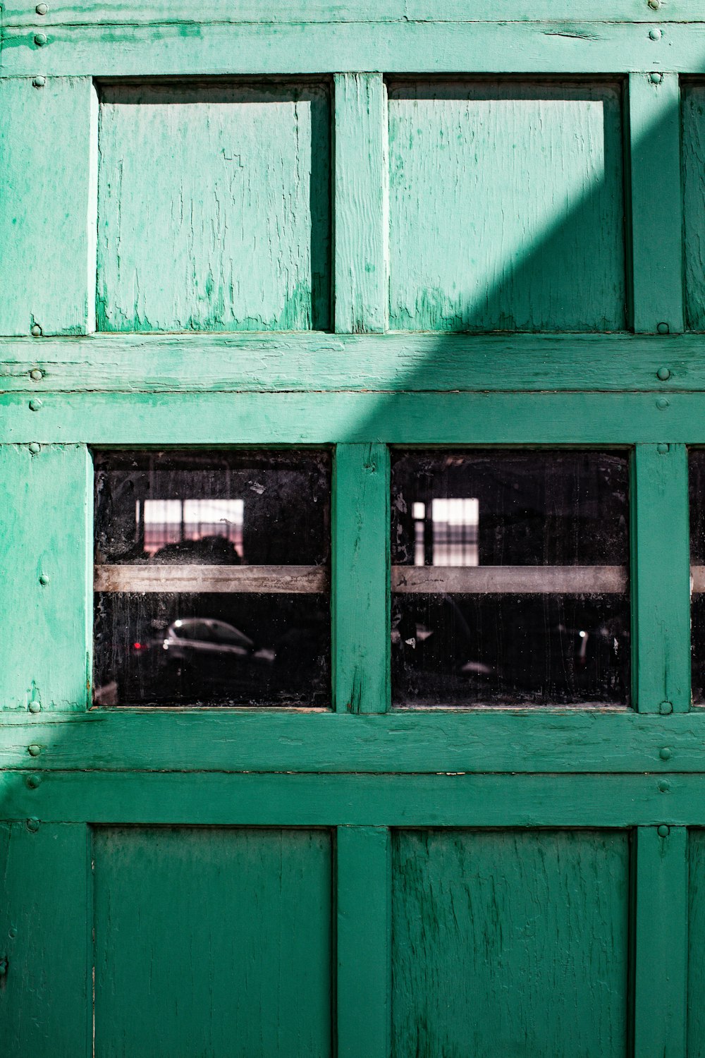 a close up of a green door with a window