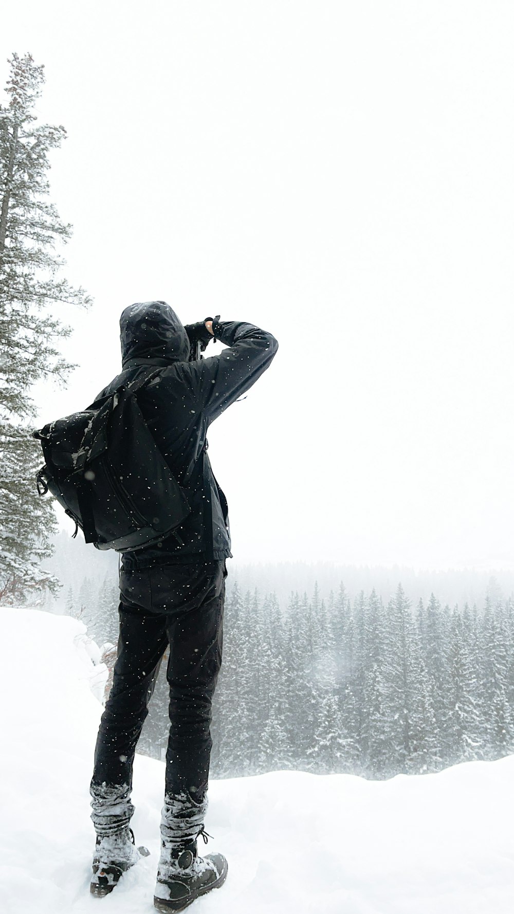 a man standing on top of a snow covered slope