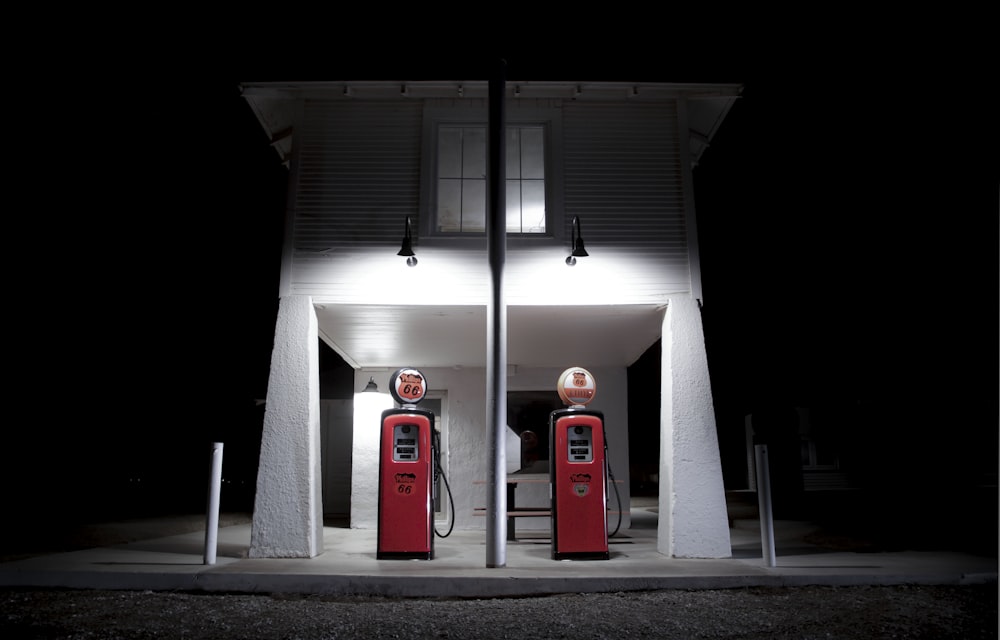a couple of red gas pumps sitting in front of a building