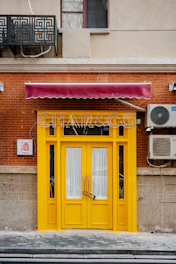 Bright yellow storefront with golden key emblem and animated mascot floating nearby