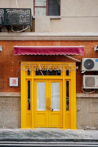 Bright yellow storefront with golden key emblem and animated mascot floating nearby