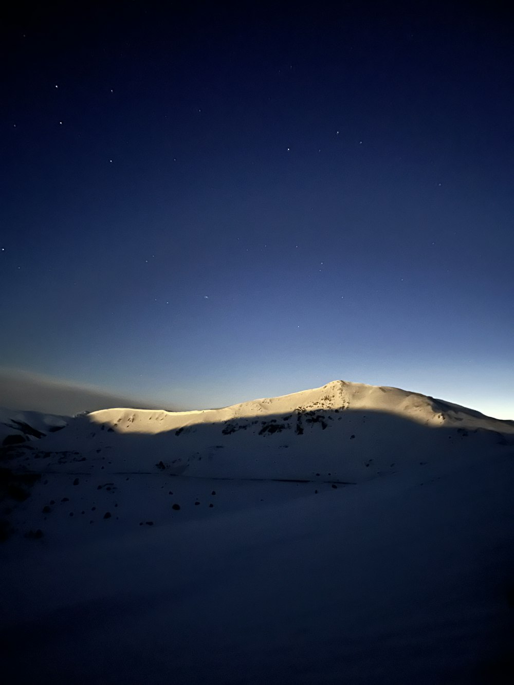 a snow covered mountain under a night sky