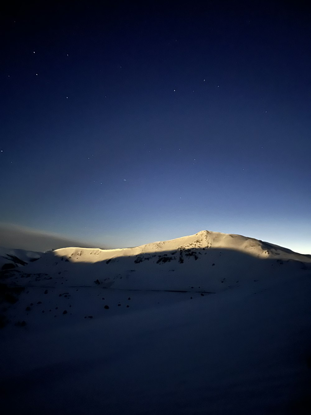 Una montaña cubierta de nieve bajo un cielo nocturno