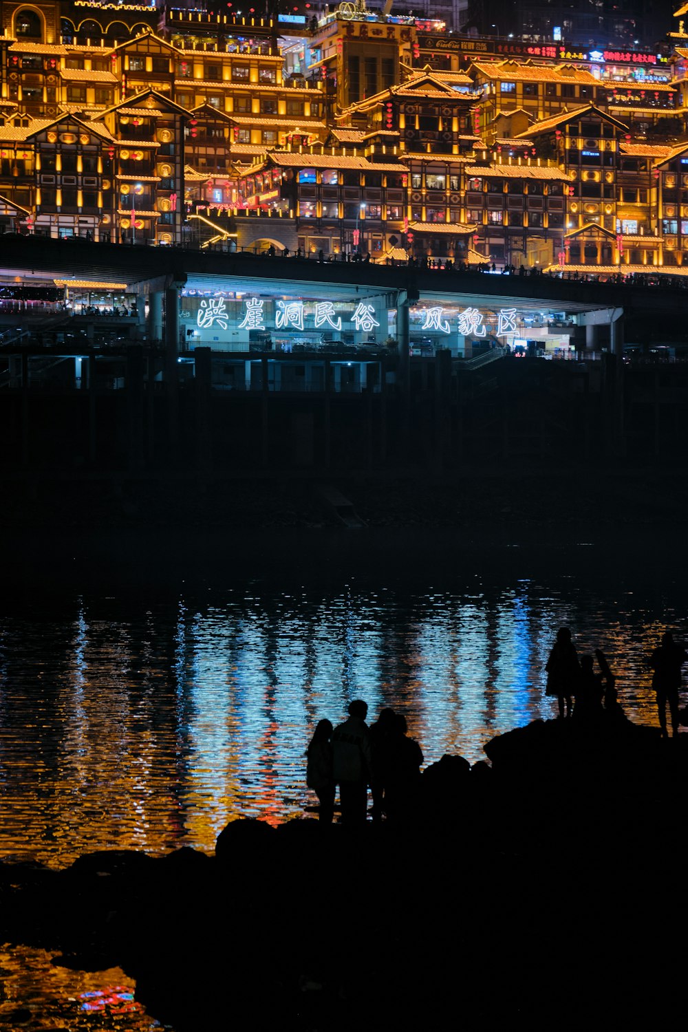 a group of people standing next to a body of water