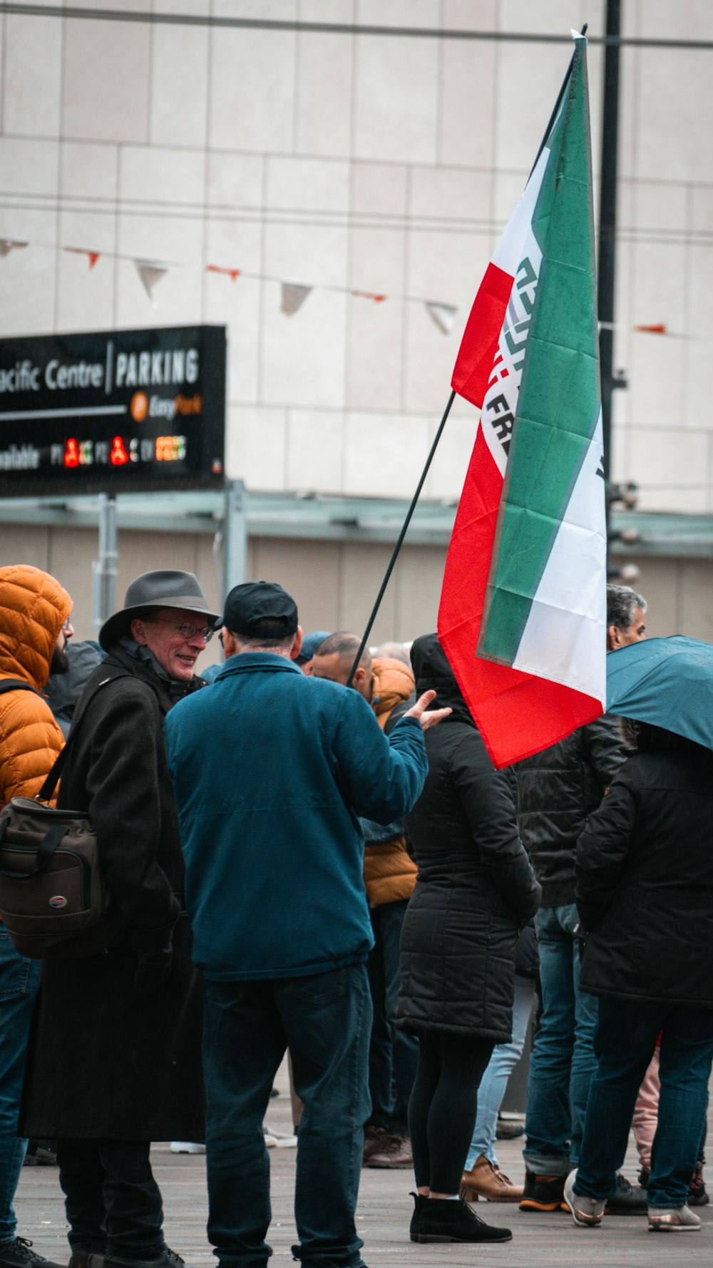 a group of people standing around each other holding a flag