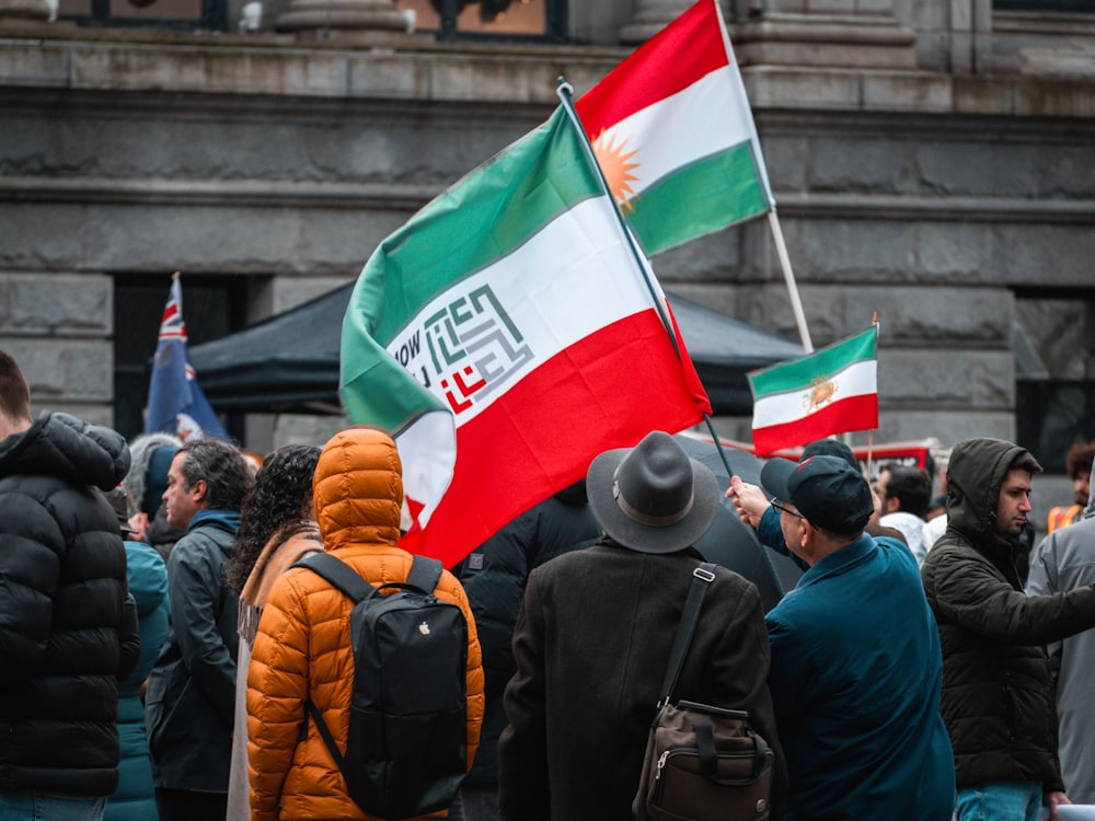 un groupe de personnes tenant des drapeaux devant un bâtiment