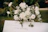 Handcrafted wooden wedding welcome sign with elegant floral decorations in a rustic setting.
