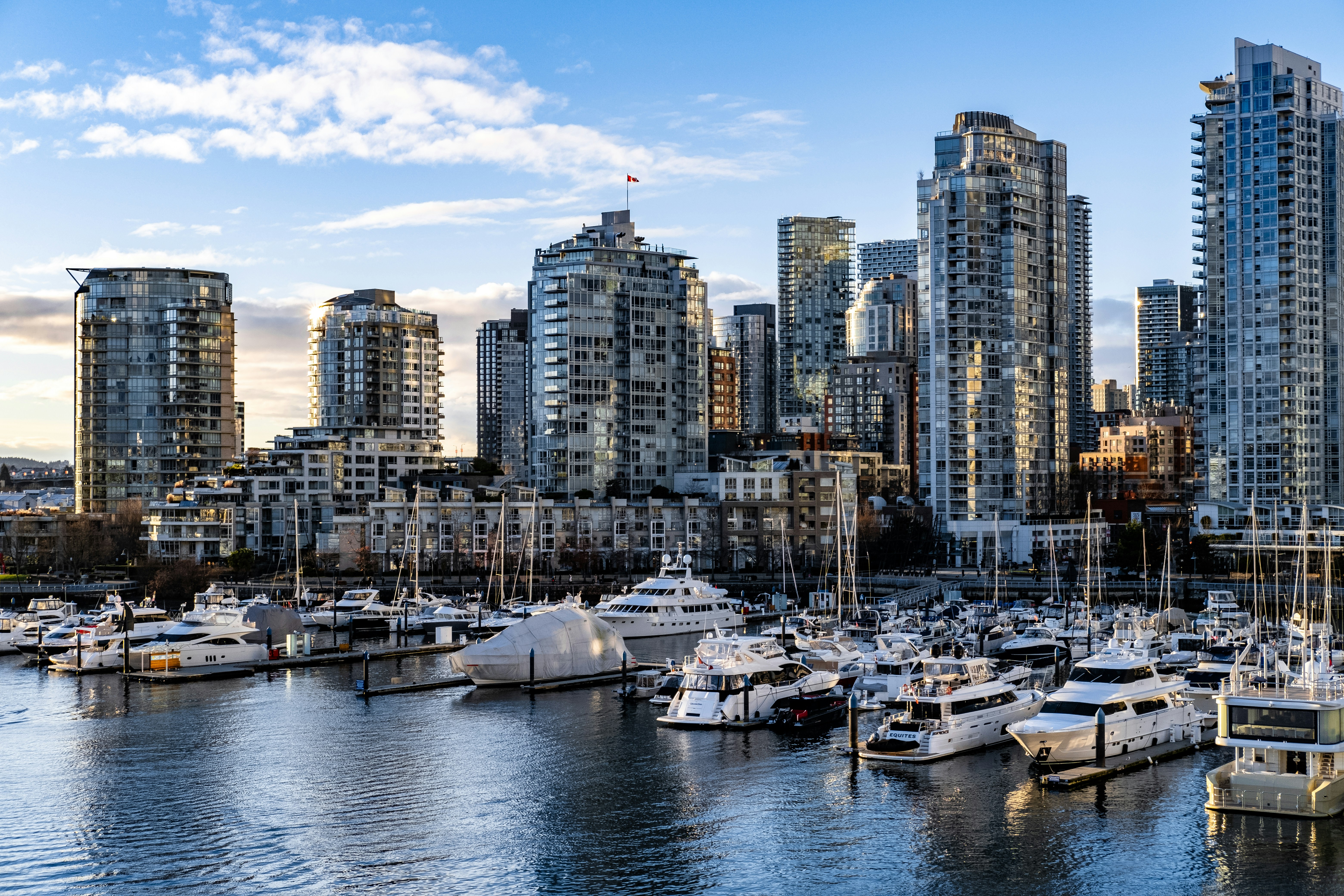 a harbor filled with lots of boats next to tall buildings