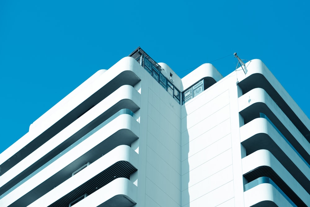 a tall white building with a blue sky in the background