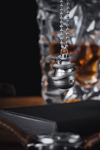 Close-up of a sleek novelty gun keyring clipped securely onto a leather belt, showcasing its vibrant color options.