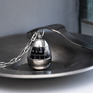 A sleek, compact kitchen timer shaped like a retro alarm clock with a sarcastic quote on its face.