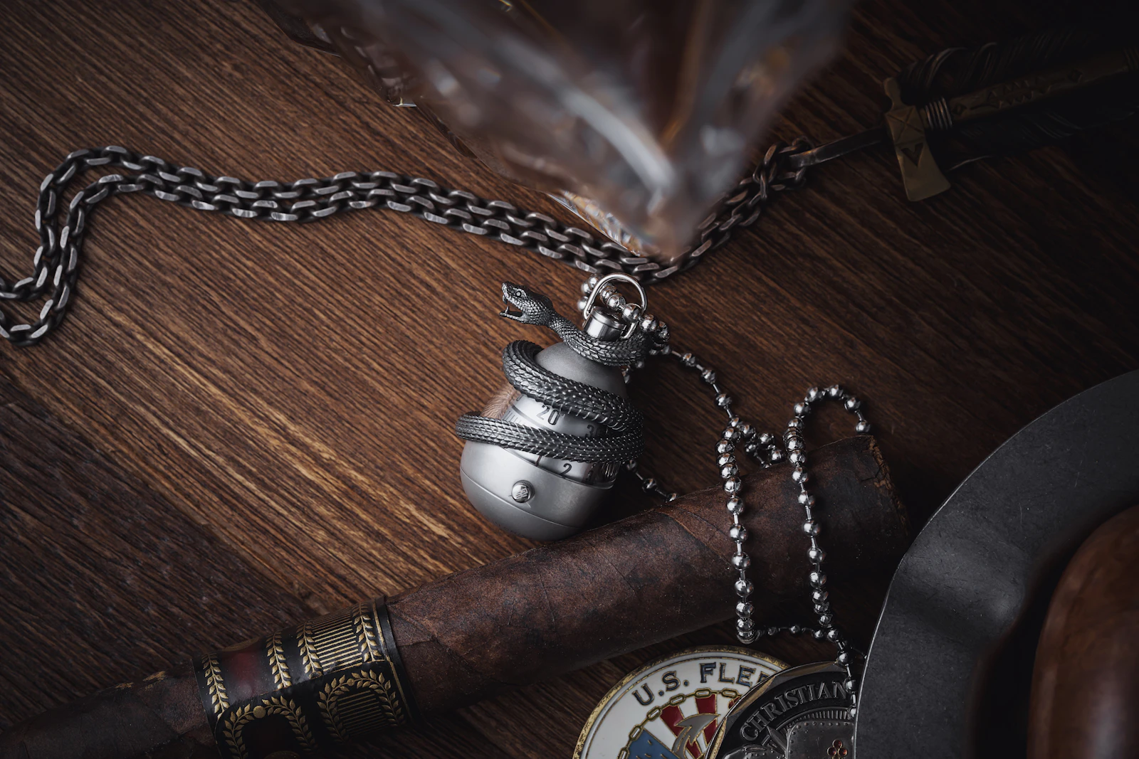 Cigar and detailed metal accessories arranged on a dark wooden table