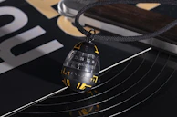 A stylish pendant necklace featuring a small section of a vinyl record with intricate grooves.