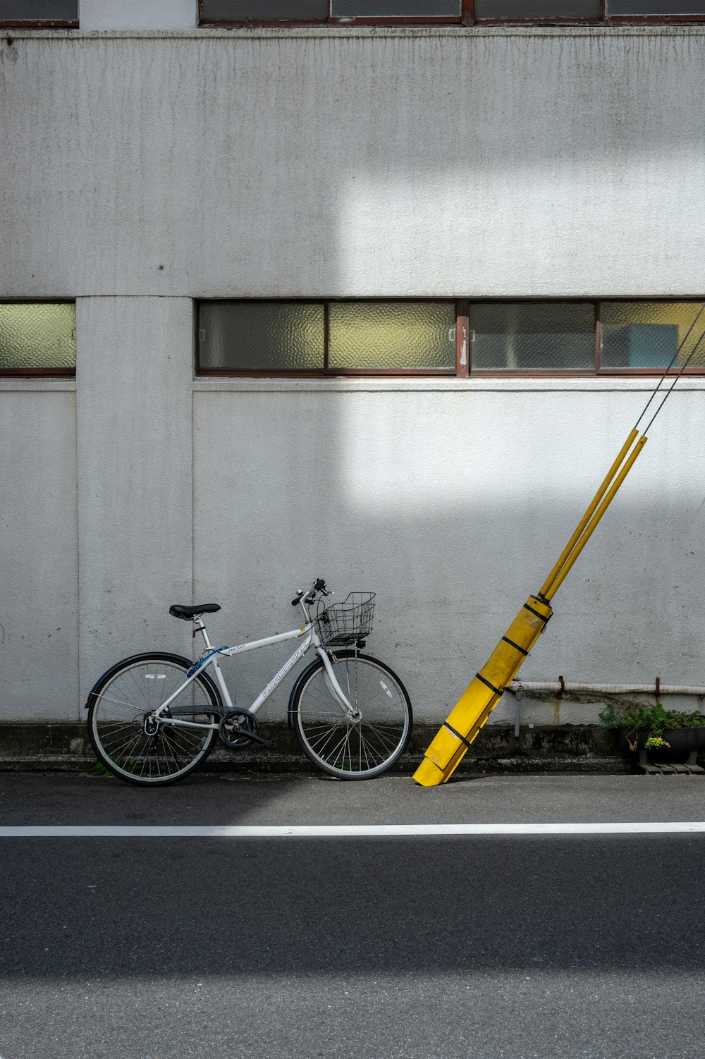 a bicycle parked next to a pole on the side of a road