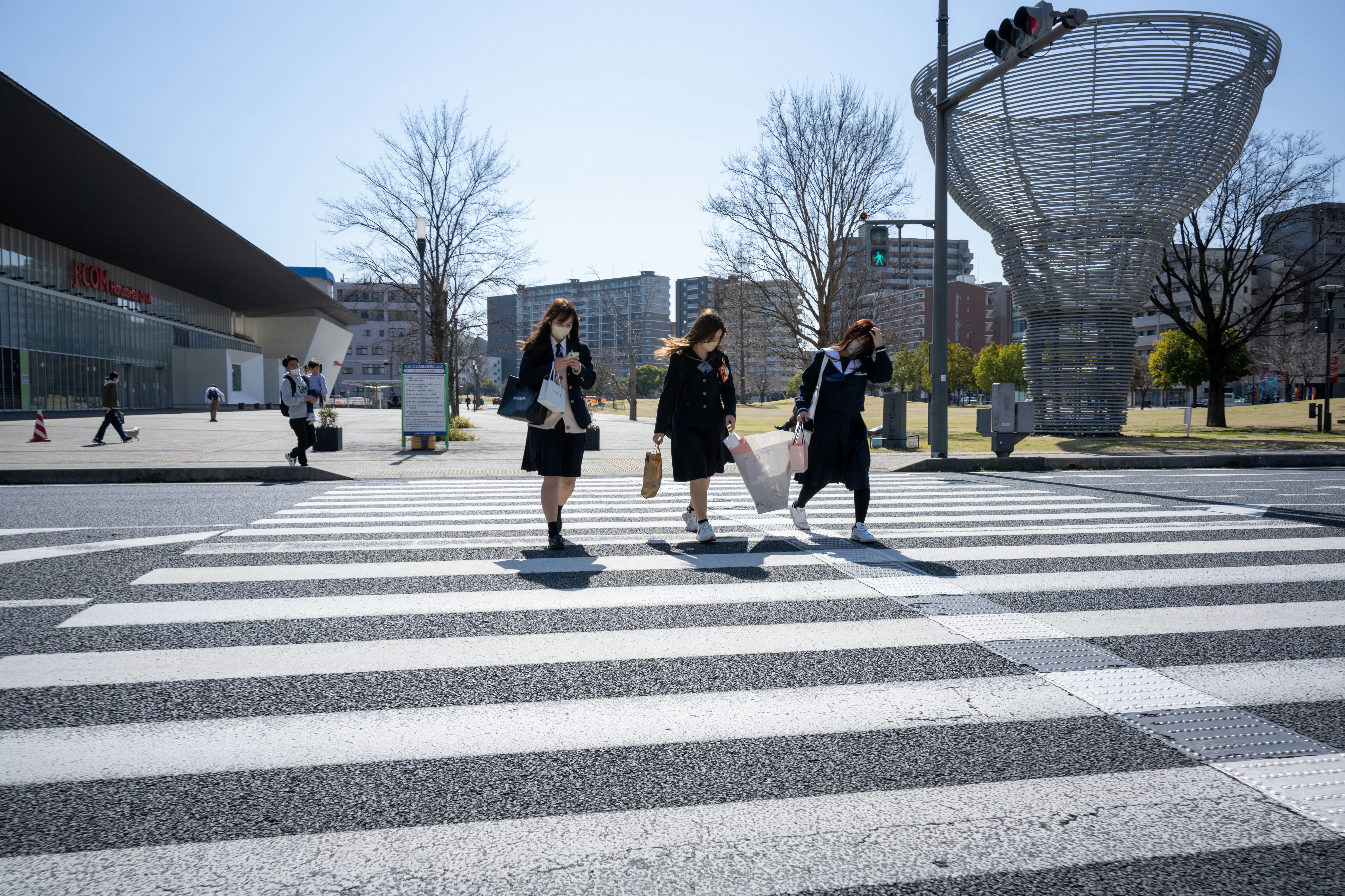 a group of people walking across a cross walk