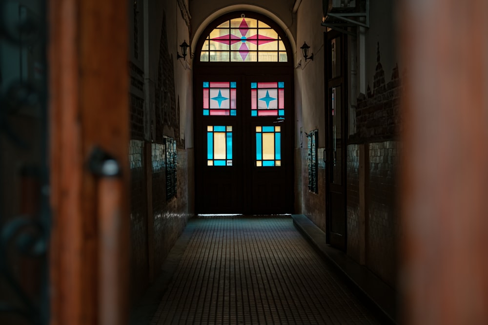 a hallway leading to a stained glass door