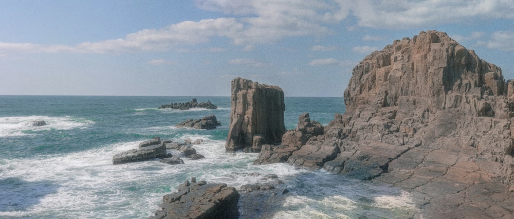 a large rock outcropping in the middle of the ocean