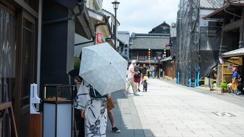 a woman holding an umbrella on a city street