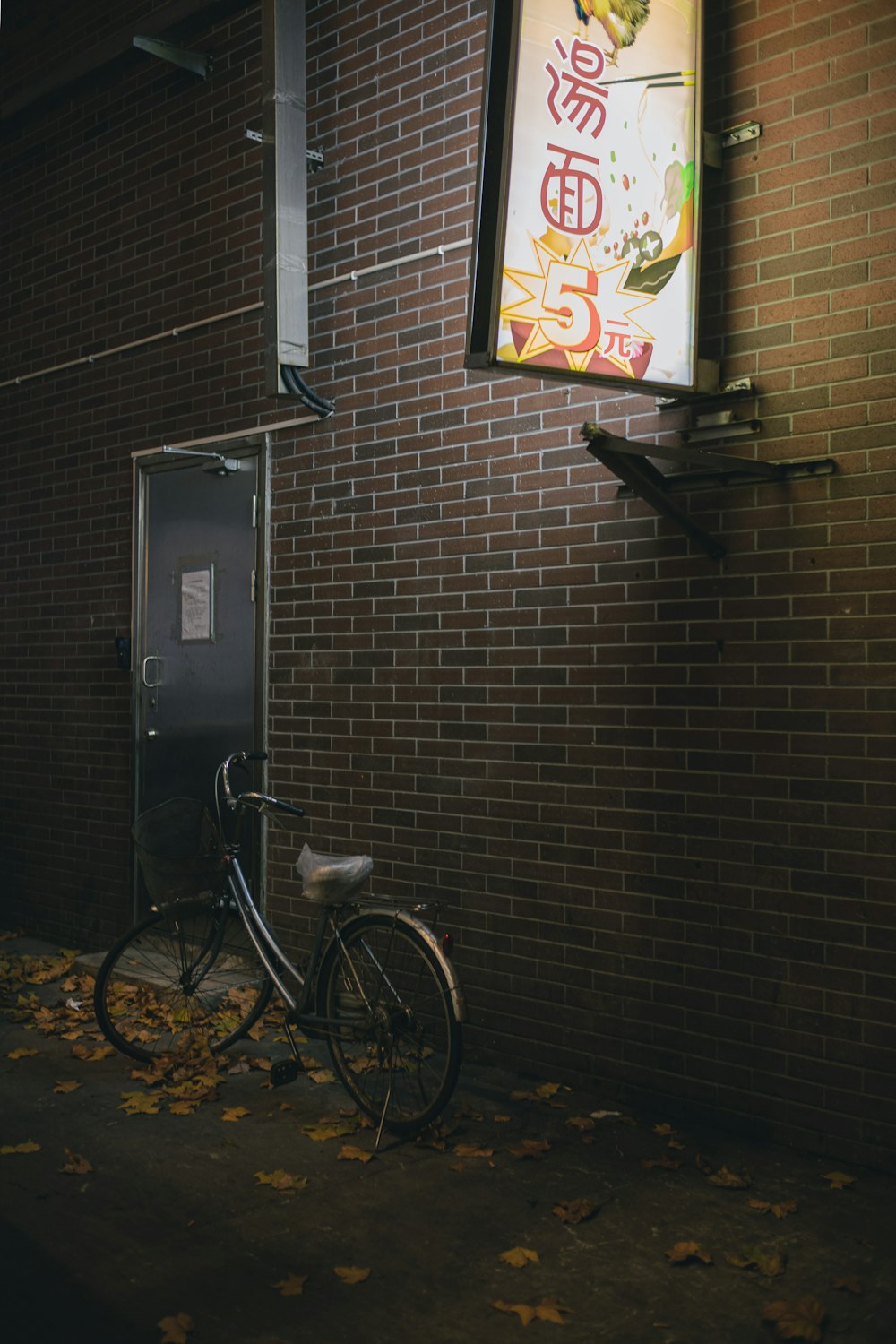 Una bicicleta está estacionada contra una pared de ladrillos
