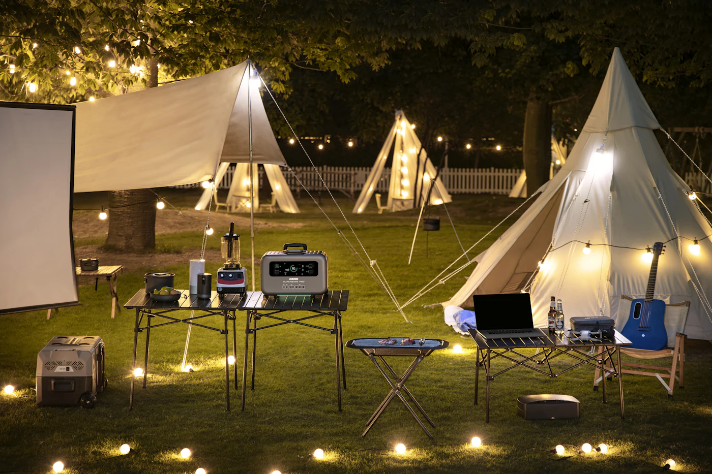 A group of tents set up in a grassy field with portable power