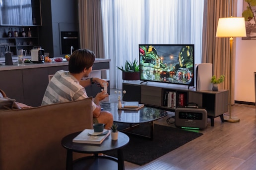 A cozy living room setup with a person enjoying watching a movie on a large screen using goto77 video platform.