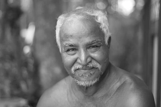 An elderly man performing balance exercises with a calm and focused expression.