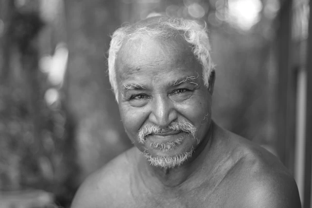 An elderly man performing balance exercises with a calm and focused expression.