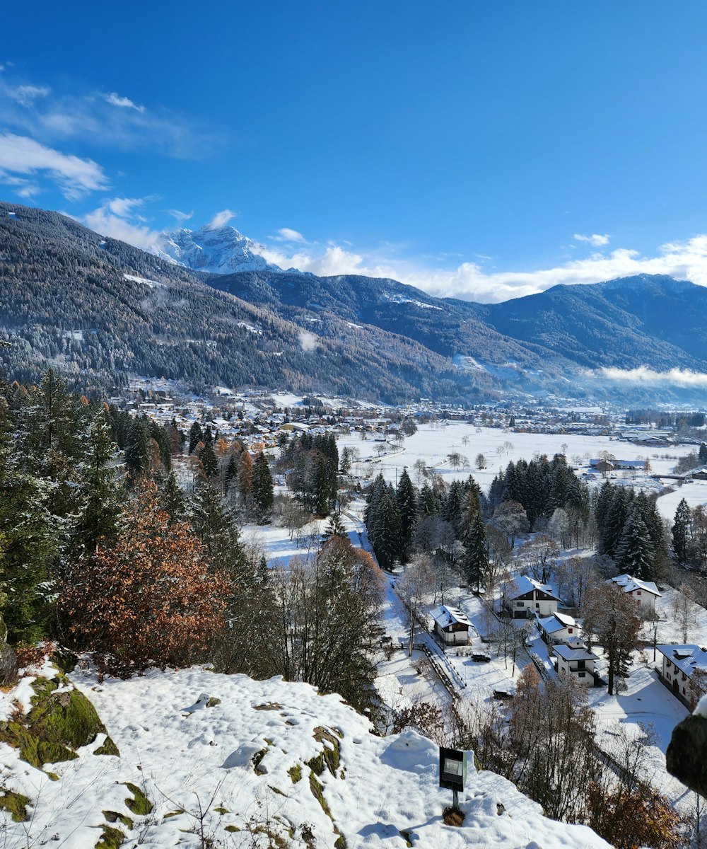 a view of a town in the mountains covered in snow