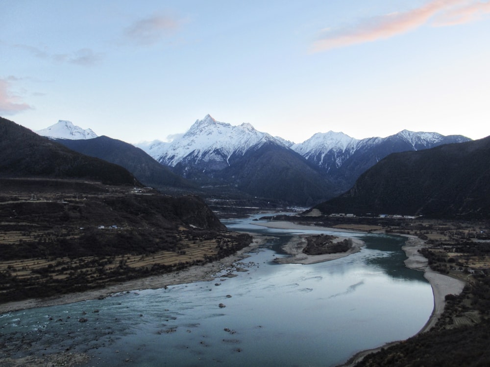 a river running through a valley surrounded by mountains