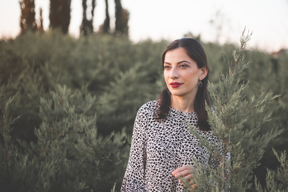 a woman standing in a field of tall grass