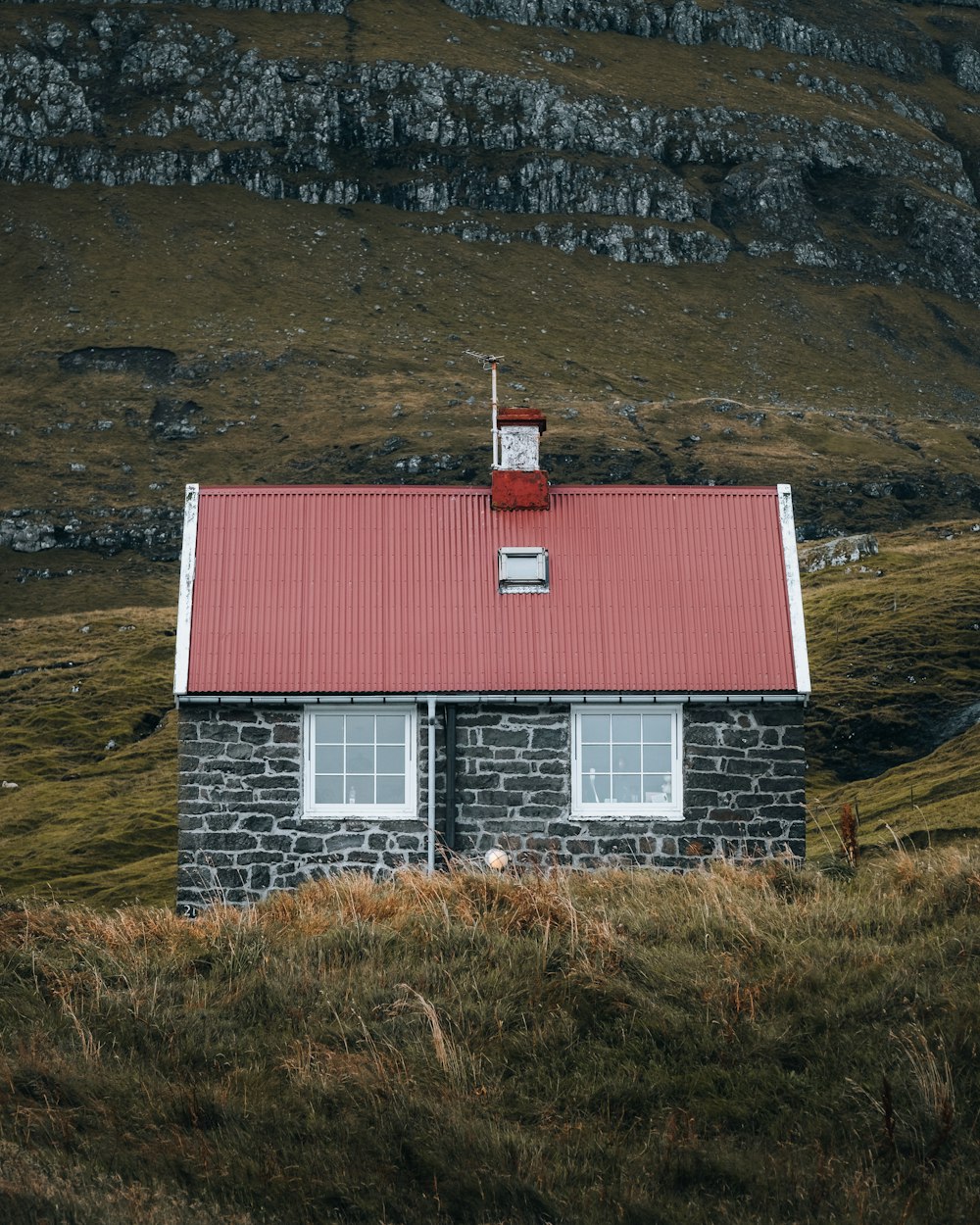 a small brick building with a red roof