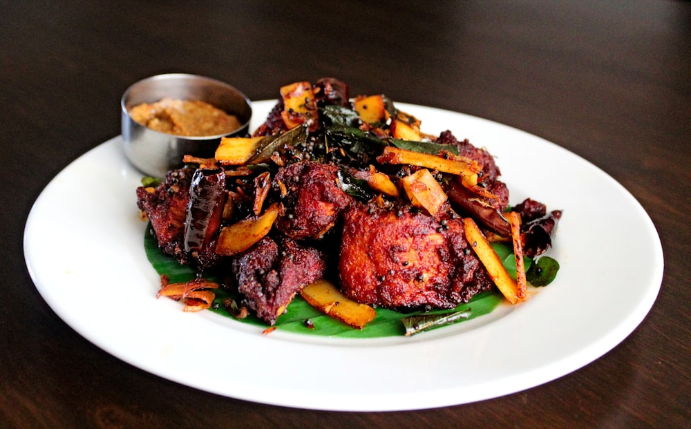 a white plate topped with meat and veggies