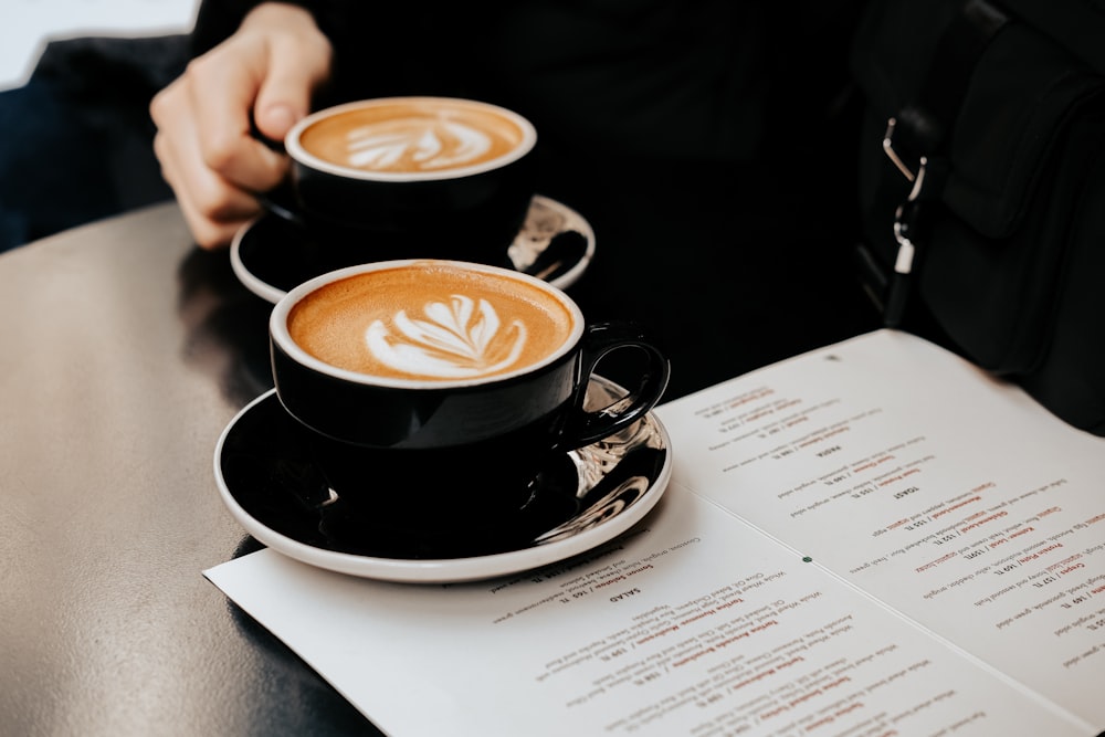 two cups of coffee sitting on top of a table