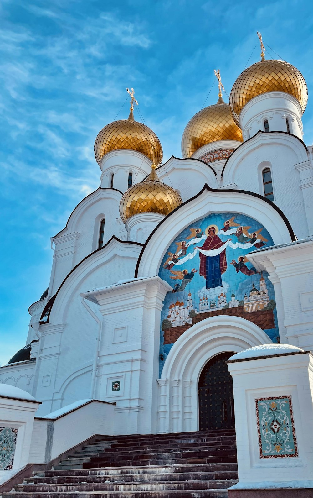 a white church with gold domes under a blue sky