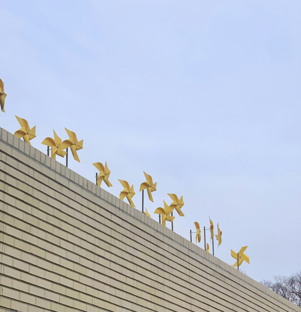 a row of yellow origami birds on top of a building