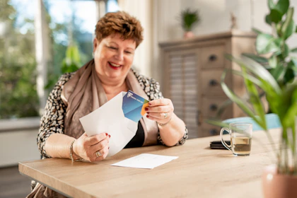 Smiling customer receiving a package from an online order at home.