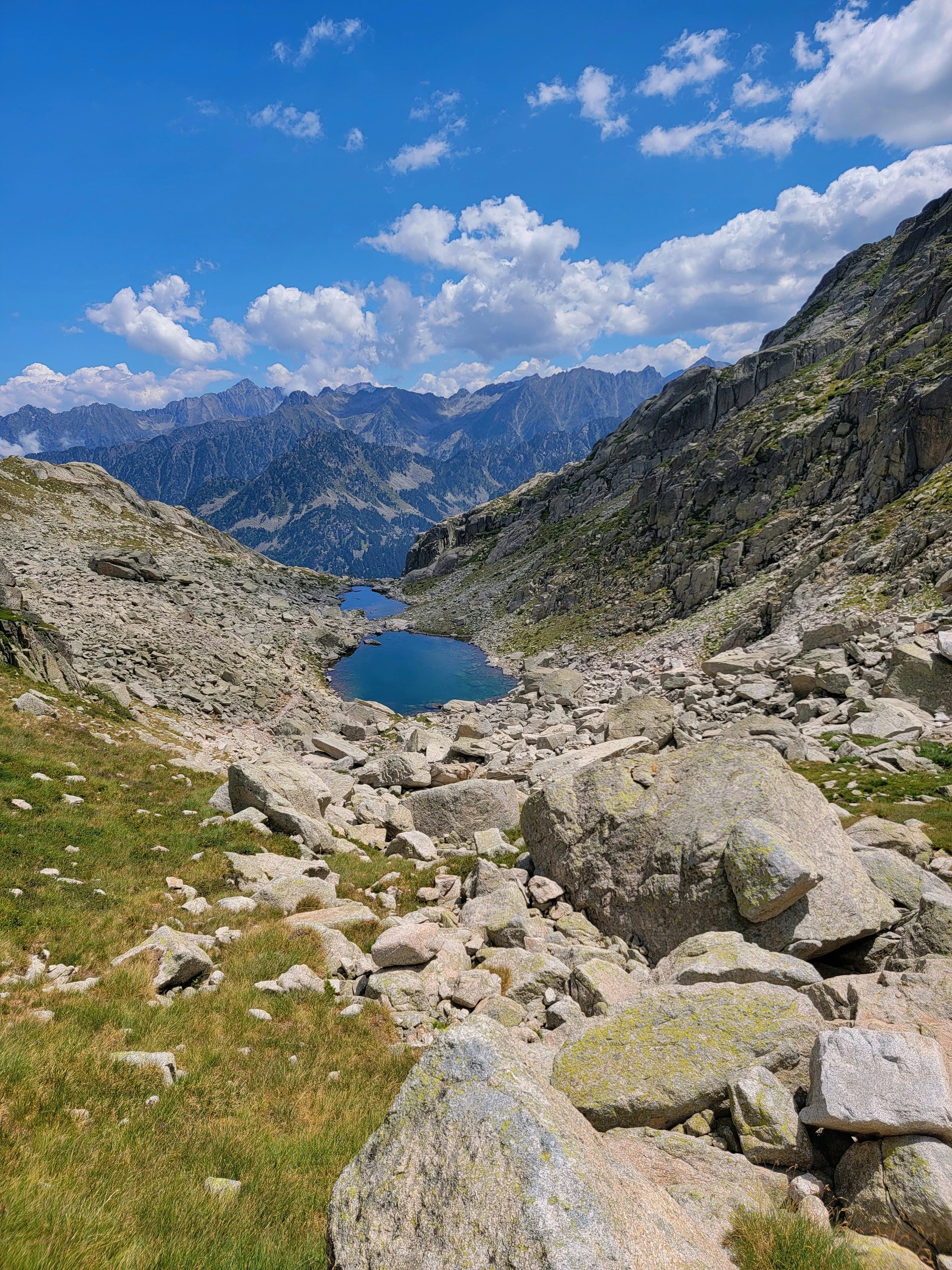 a view of a lake surrounded by rocks and grass
