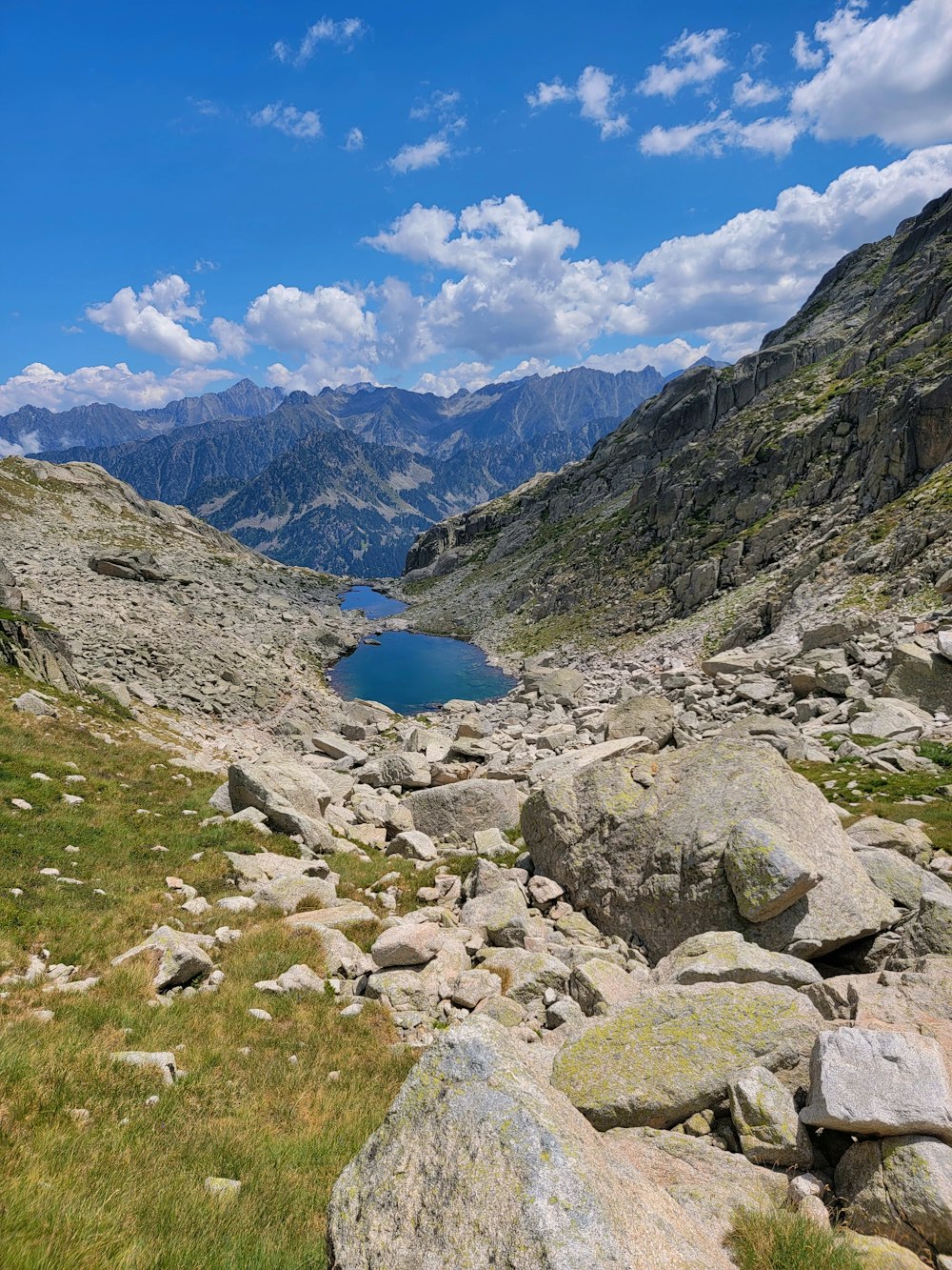 una vista di un lago circondato da rocce ed erba