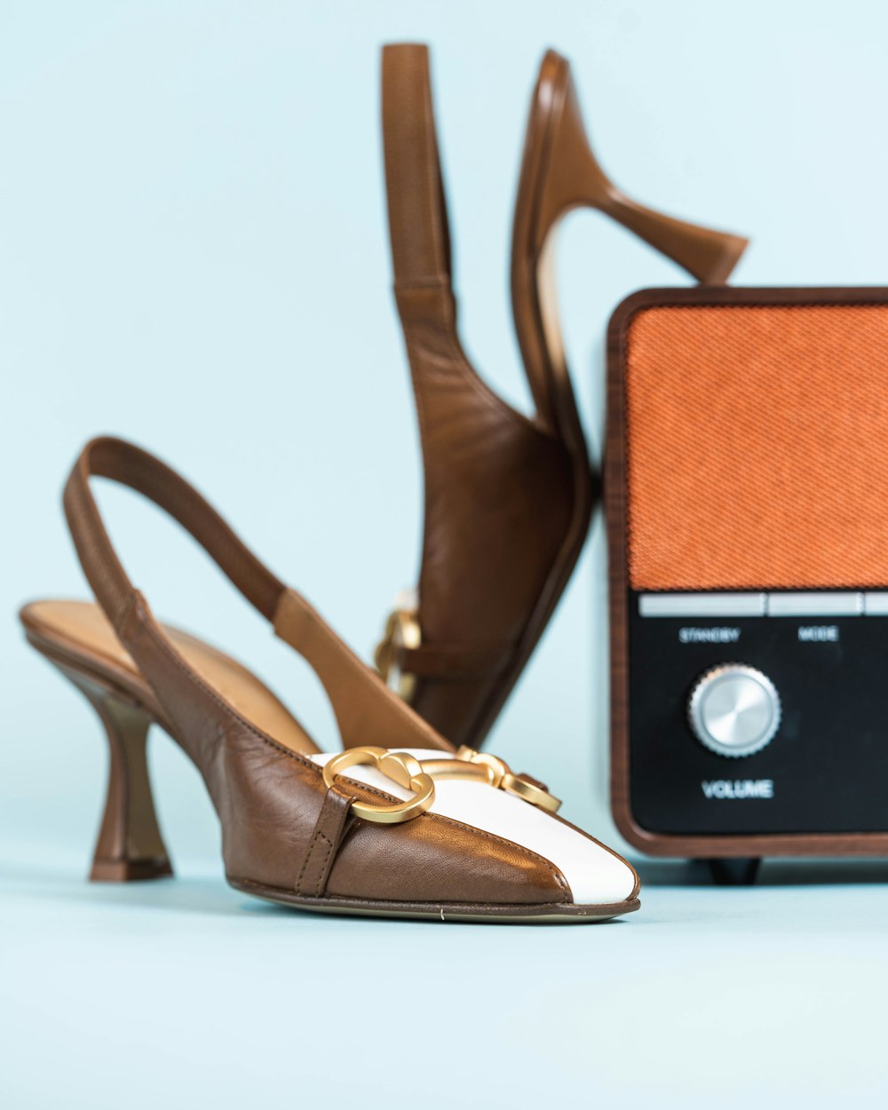 a pair of brown and white shoes next to a radio