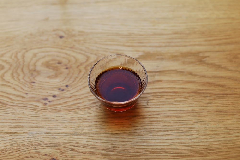 a glass of wine sitting on top of a wooden table