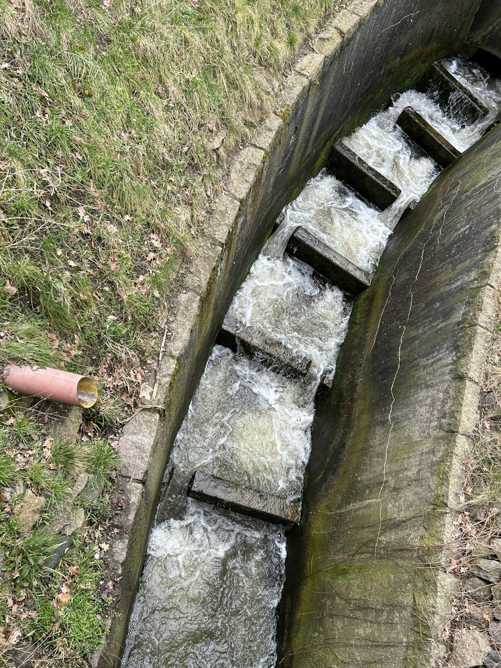 un piccolo corso d'acqua che scorre su una struttura in legno