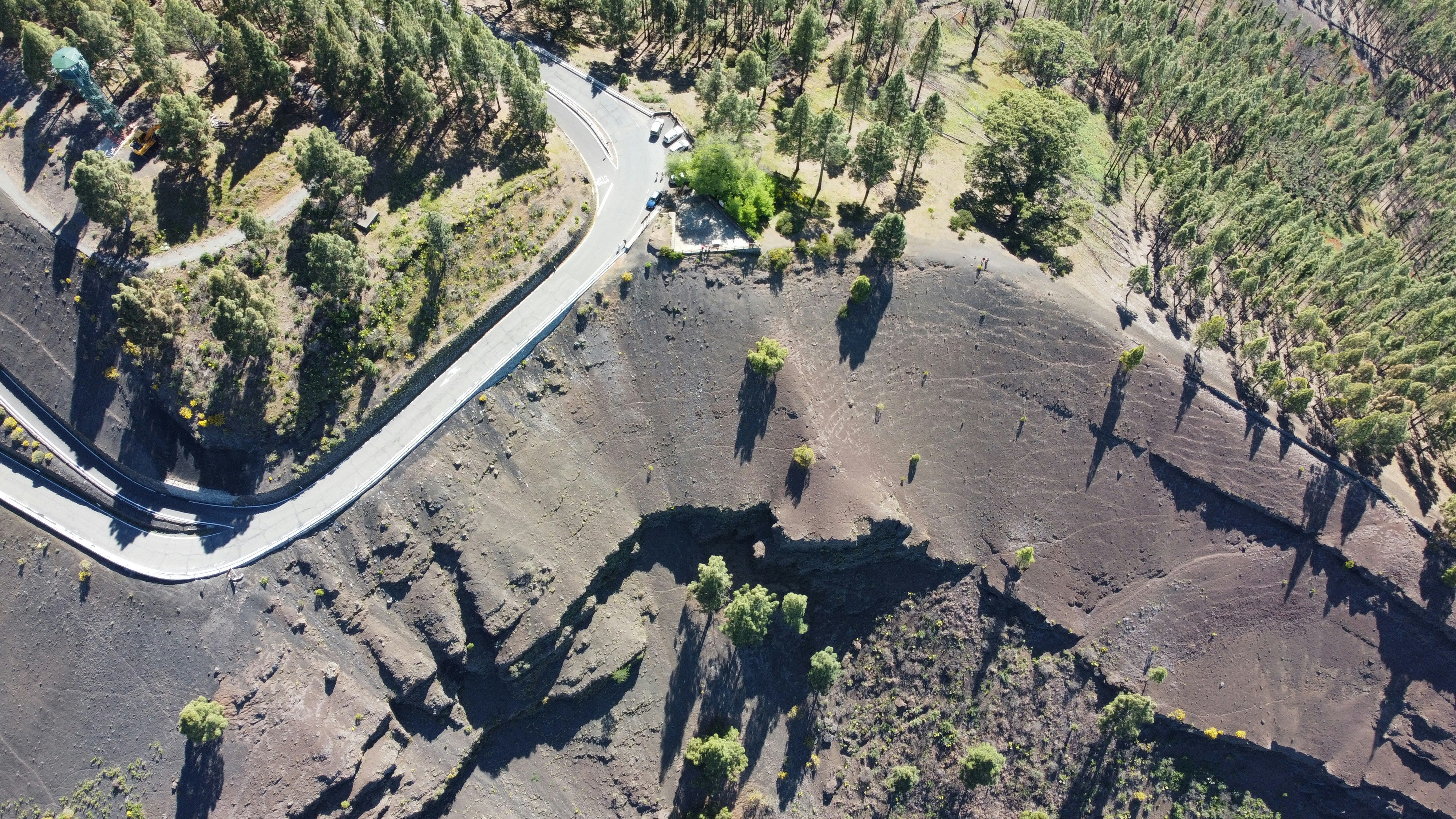 an aerial view of a winding road surrounded by trees