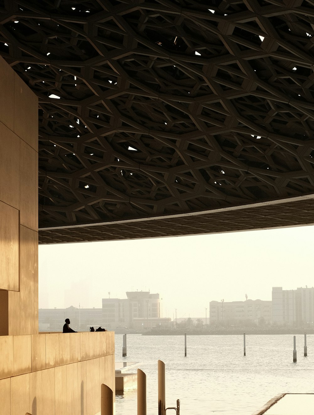 a person sitting on a bench under a bridge