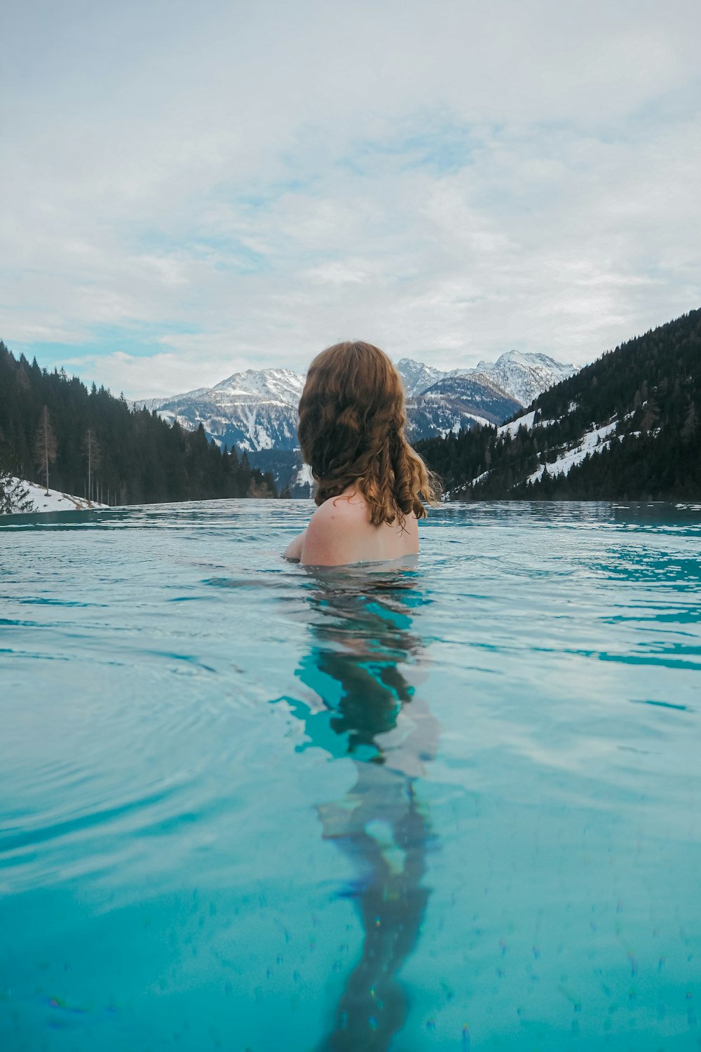 a woman is sitting in the middle of a body of water