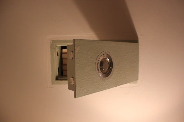 A sturdy steel home safe with a digital lock, placed in a cozy living room corner.