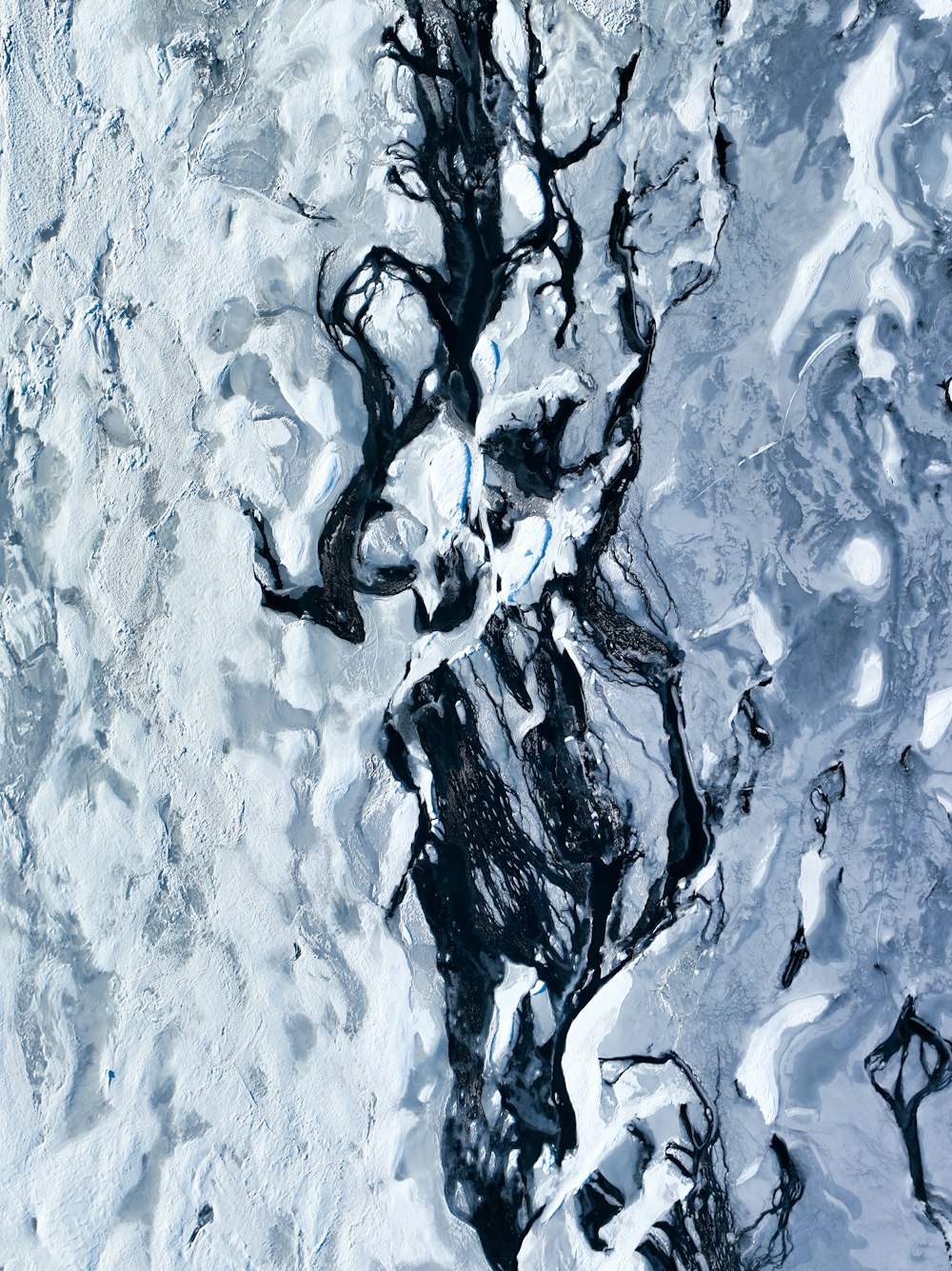 an aerial view of a river in the snow