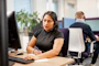 Smiling businesswoman using a phone headset in a bright office environment.